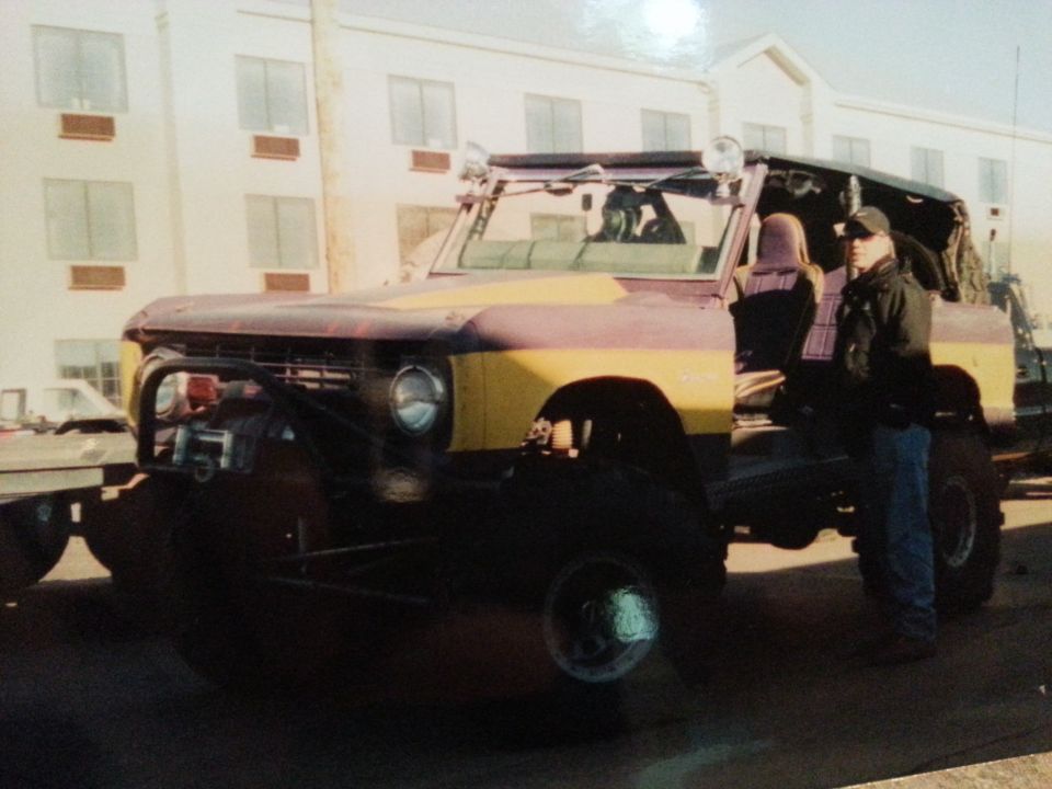 Yellow and maroon Ford Bronco with off-road modifications