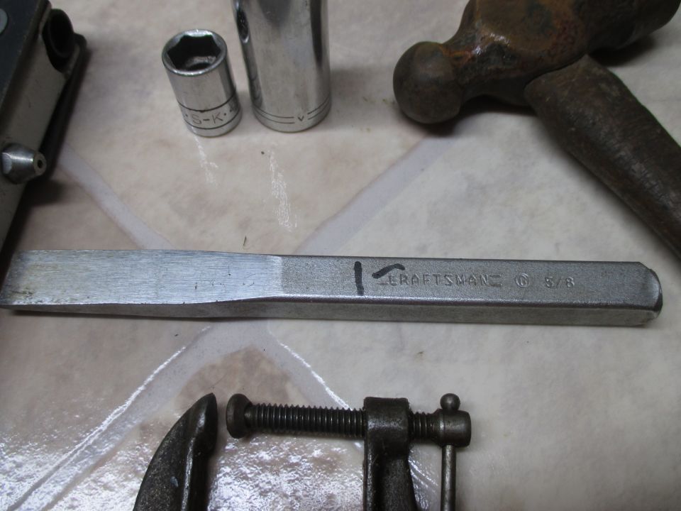 Chisel with 'CRAFTSMAN' and '5/8' markings, socket wrenches, and a hammer