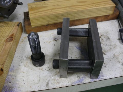 1976 Chevrolet Corvette - A bolt and a metal jig are on a workbench, alongside wooden blocks.