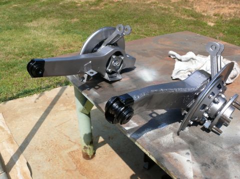 1976 Chevrolet Corvette - Two car suspension control arms are laid out on a table, likely awaiting installation or further work.