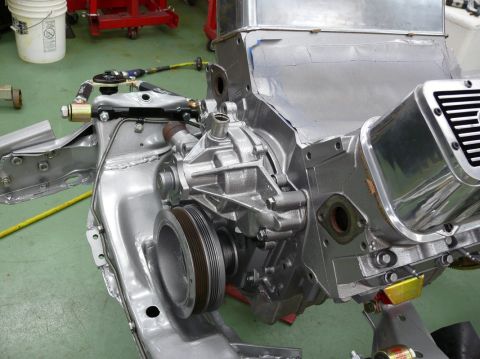 1976 Chevrolet Corvette - Close-up view of a car engine's water pump and pulley system during assembly.