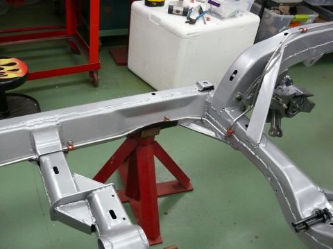 1976 Chevrolet Corvette - The chassis of a car is shown on jack stands, likely undergoing restoration or repair.