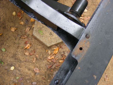 Close-up of black metal vehicle frame part with rust spots