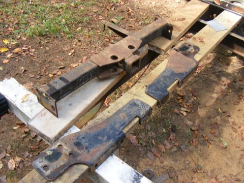two rusty metal frame pieces resting on wood planks outdoors