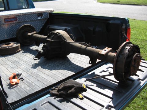 Rear axle assembly with drum brakes and a Duralast toolbox in a pickup truck bed