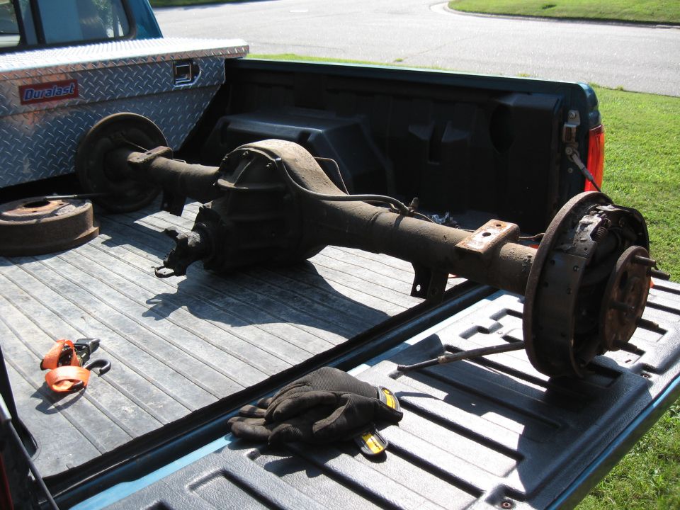 Rear axle assembly with drum brakes and a Duralast toolbox in a pickup truck bed