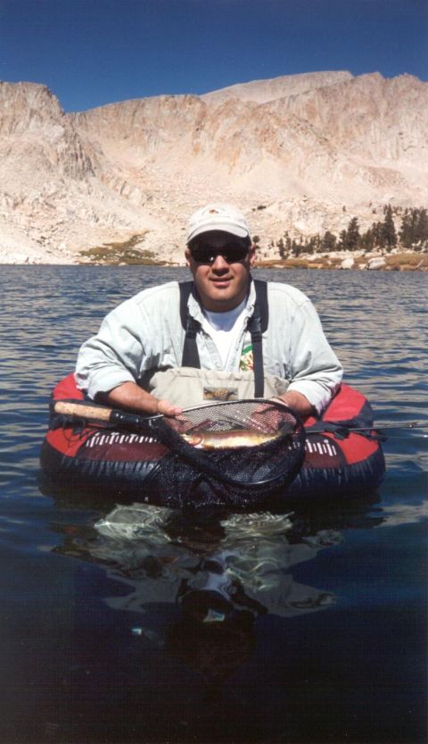 1996 Ford Bronco - Man enjoys a day of fishing in a mountain lake, holding his catch.