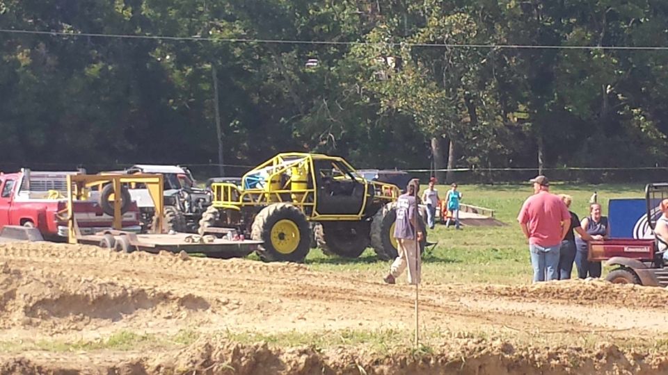 Yellow custom off-road truck with roll cage and large tires