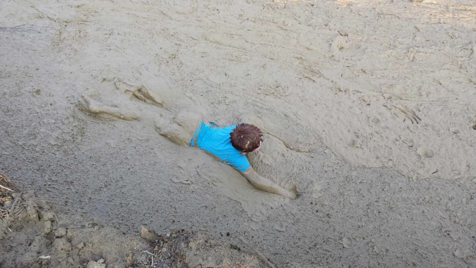 Person stuck in mud, blue shirt, Supermotors logo in corner