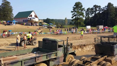 1987 Ford Bronco - Mud bogging event with multiple vehicles and spectators at an outdoor venue.