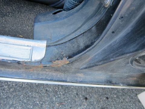 2001 Ford Crown Victoria - Rust is visible on the lower edge of the door frame, near the door sill plate.