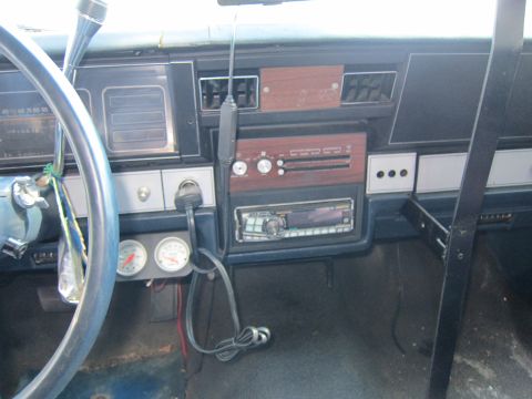 2001 Ford Crown Victoria - The interior of a vehicle features an aftermarket radio and additional gauges mounted below the dashboard.