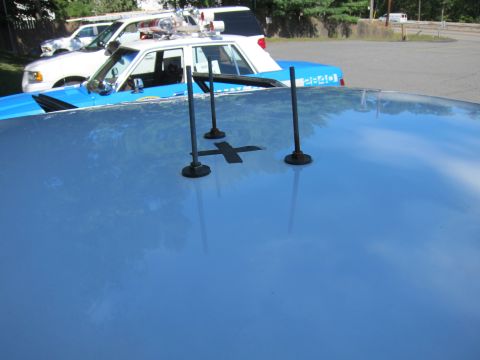 2001 Ford Crown Victoria - Antennas mounted on the roof of a police vehicle, with another car visible in the background.