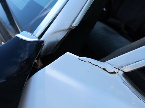 2001 Ford Crown Victoria - Rust is forming on the edge of the car's door frame, indicating potential body damage.