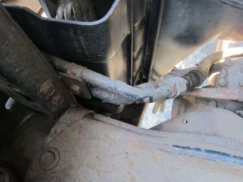 2001 Ford Crown Victoria - Close-up view of a vehicle's brake line and suspension components, showing signs of rust.