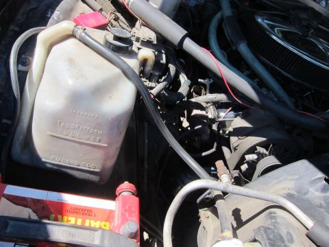 2001 Ford Crown Victoria - Close-up view of an engine bay, showing a coolant reservoir and battery.