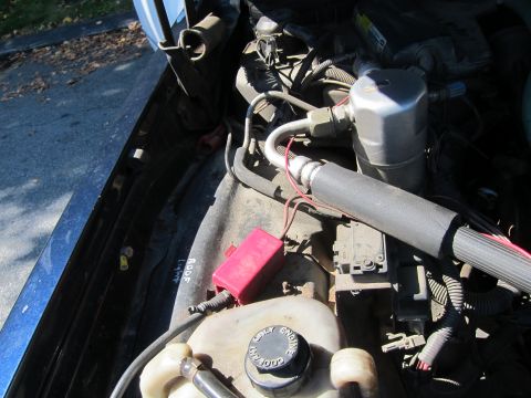 2001 Ford Crown Victoria - Close-up view of engine bay components, including AC system parts and a fuse box.