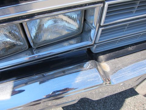 2001 Ford Crown Victoria - Close-up of the front of a 2001 Ford Crown Victoria, showing the bumper, headlight, and grille details.