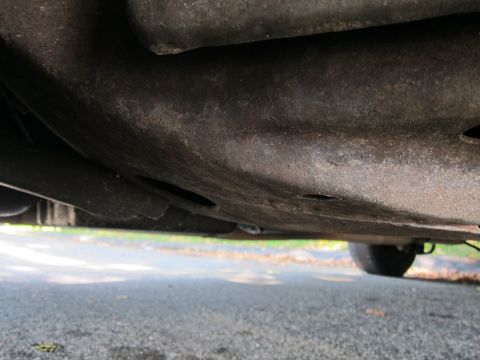 2001 Ford Crown Victoria - The undercarriage of a vehicle is shown, with a tire visible on the right side.