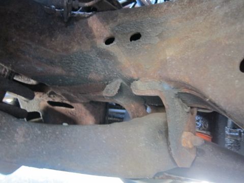 2001 Ford Crown Victoria - Close-up view of heavily rusted undercarriage parts, showing significant corrosion.