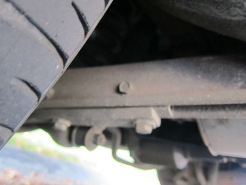 2001 Ford Crown Victoria - Close-up view of the undercarriage, showing suspension parts and a tire.