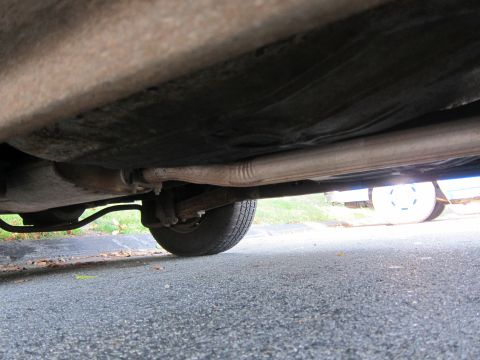2001 Ford Crown Victoria - A low-angle view of a vehicle's undercarriage, revealing the exhaust system and a rear tire.