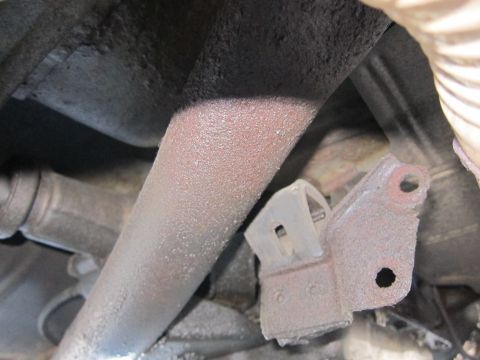 2001 Ford Crown Victoria - Underside view of a vehicle's exhaust system, showing a corroded pipe and mounting bracket.