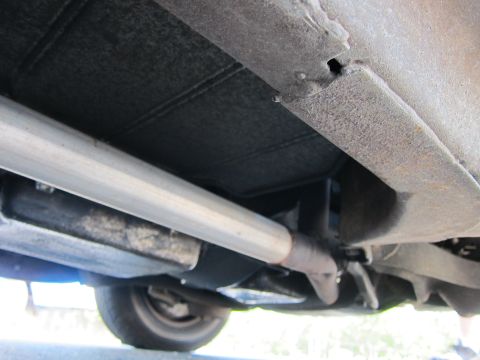 2001 Ford Crown Victoria - Underside view of a vehicle, highlighting the exhaust system and a portion of the tire.
