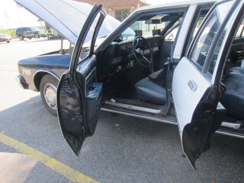 2001 Ford Crown Victoria - Photo of a Chevrolet Caprice police cruiser interior with doors open, not a technical document.