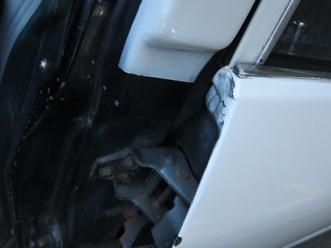 2001 Ford Crown Victoria - Photograph of a car door hinge and jamb, not a technical document.