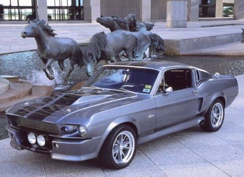 1990 Ford Bronco - This classic muscle car features racing stripes and is parked near a water feature with horse statues.