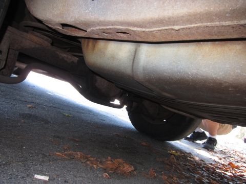 2001 Ford Crown Victoria - Close-up of a vehicle's exhaust system and rear suspension components.
