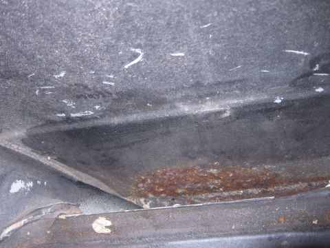 2001 Ford Crown Victoria - Close-up view of the undercarriage, showing areas of rust and protective coating.