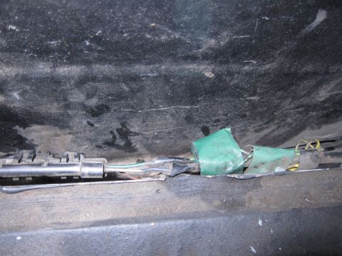 2001 Ford Crown Victoria - Close-up of electrical wiring, taped with green material, under a vehicle.