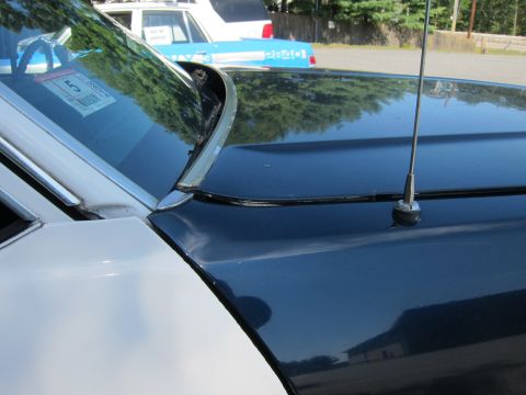 2001 Ford Crown Victoria - Close-up of a 2001 Ford Crown Victoria police car's hood and windshield, with another police vehicle visible behind it.