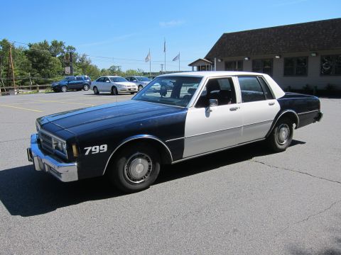 2001 Ford Crown Victoria - This two-tone sedan appears to be a police vehicle, marked with the number 799.