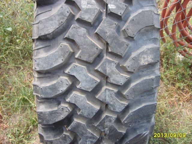 Close-up of a large off-road tire tread pattern with aggressive lugs