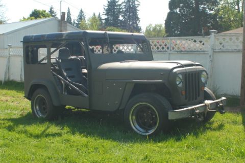 Modified Jeep CJ-5 with roll cage and racing seat, parked on grass