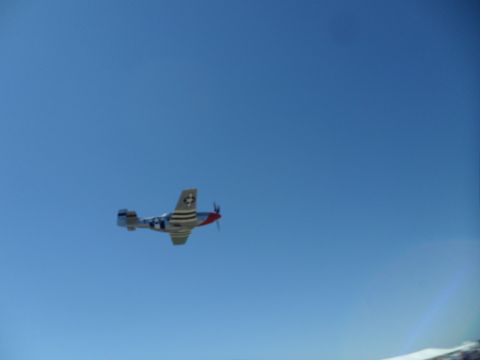 1973 Ford Ranchero - A P-51 Mustang airplane is seen in flight against a clear blue sky.