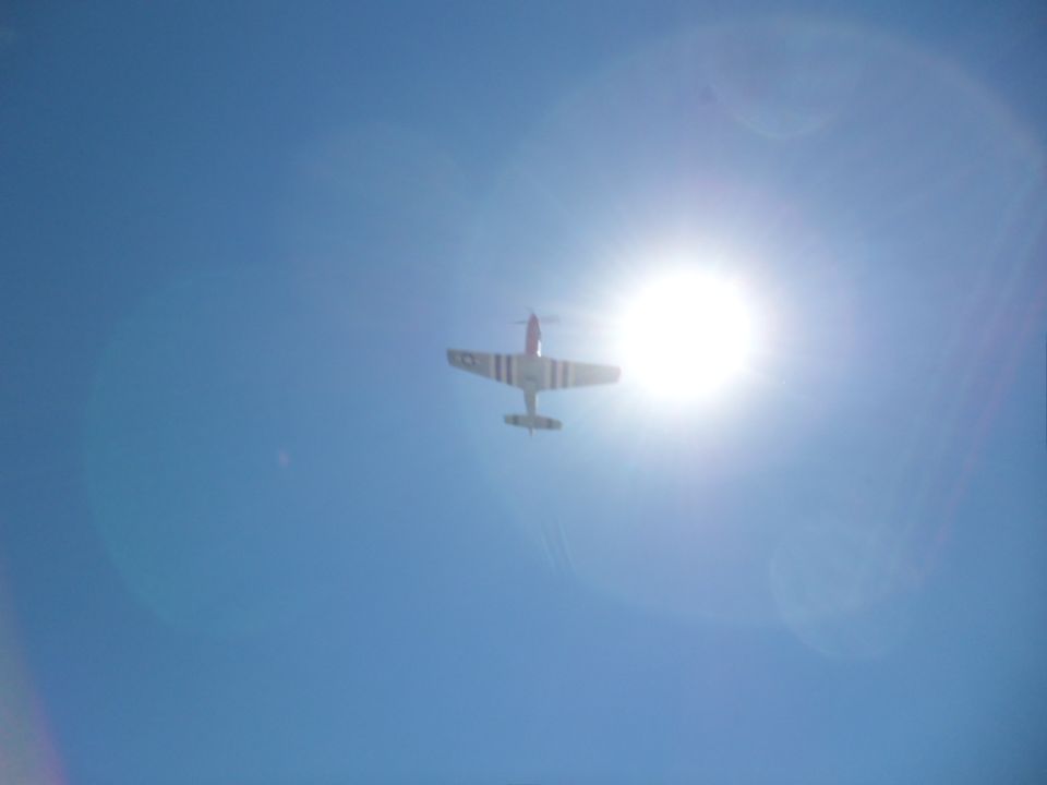 Airplane flying in the sky with sun flare