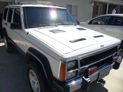 1973 Ford Ranchero - This white Jeep Cherokee XJ features aftermarket hood vents and is parked in a driveway.