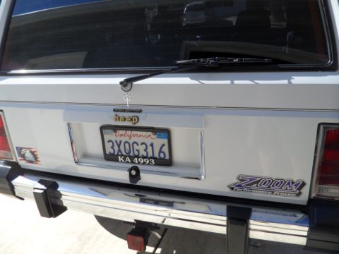 1973 Ford Ranchero - Rear view of a white Jeep SUV with a California license plate and a ZOOM performance sticker.