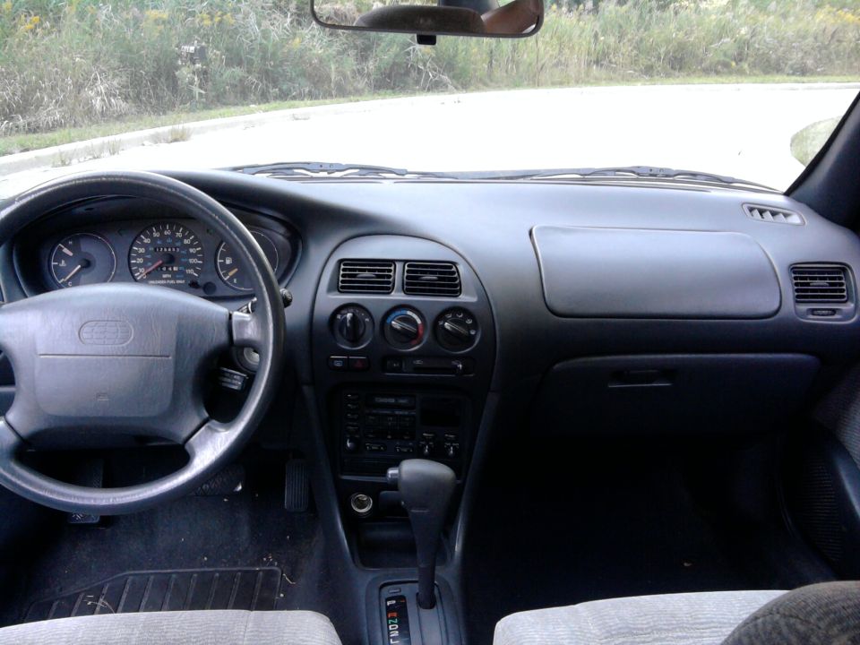 1995 Geo Metro interior showing dashboard, steering wheel, and center console