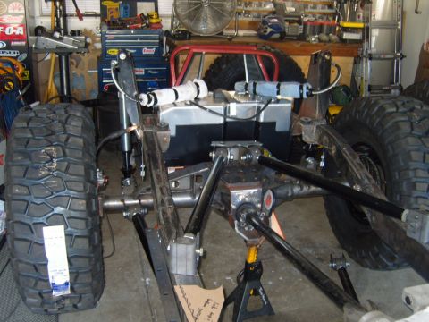 1985 Jeep CJ7 - The rear axle and suspension of a modified Jeep are visible in a workshop setting.
