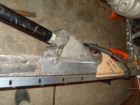 1985 Jeep CJ7 - Close-up of custom suspension fabrication, showing a link mount being welded to a frame rail with a template attached.