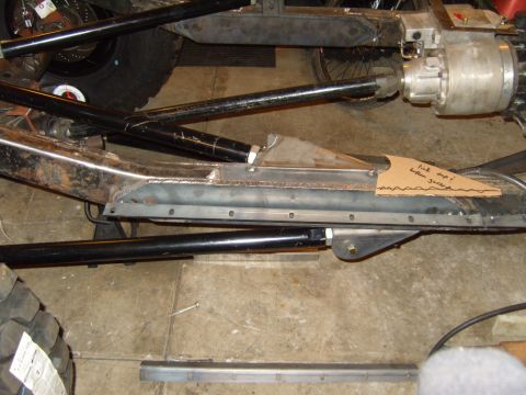 1985 Jeep CJ7 - Close-up view of a modified Jeep chassis, showing suspension components and a handwritten note on cardboard.