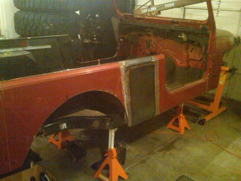 1985 Jeep CJ7 - This Jeep body is supported by jack stands in a workshop environment, showing its side profile during restoration.
