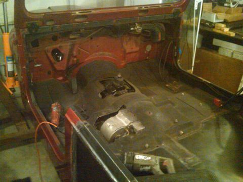 1985 Jeep CJ7 - The interior of a red Jeep CJ7 is visible, stripped down and ready for restoration work.