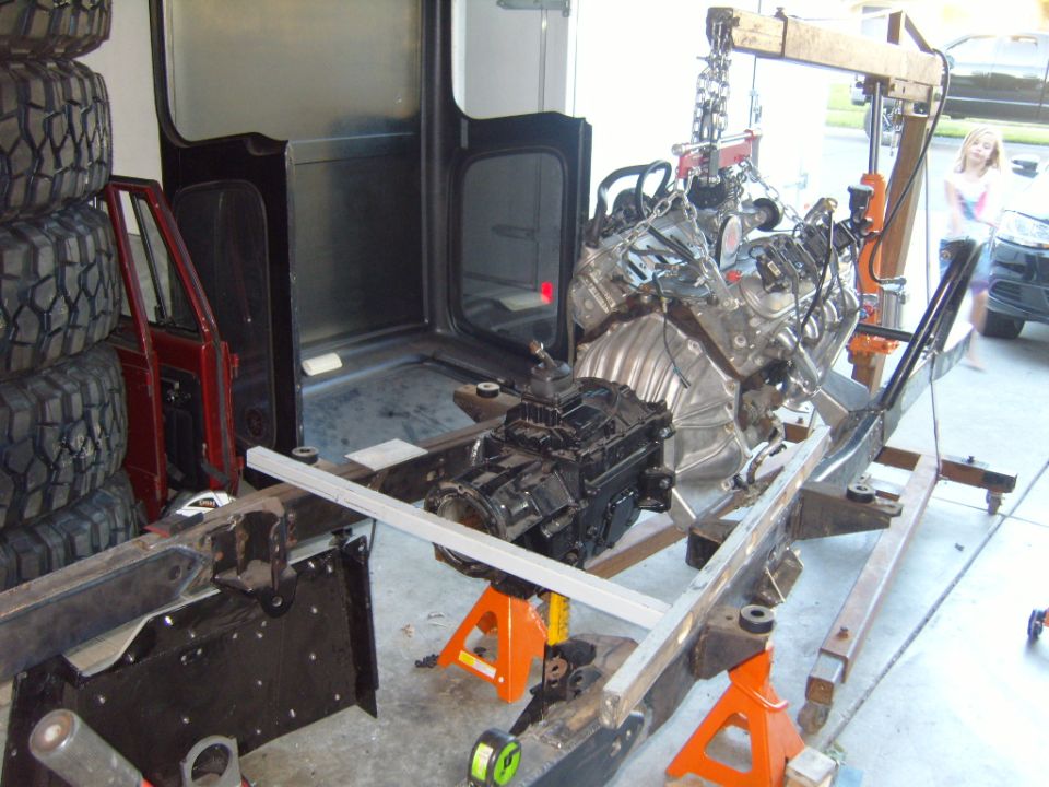 Engine and transmission assembly on a frame with tires stacked nearby