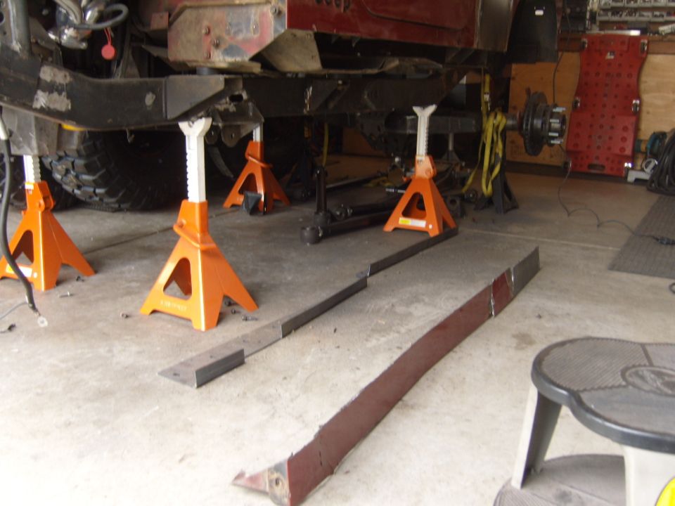 Jeep chassis on orange jack stands, with large tires visible